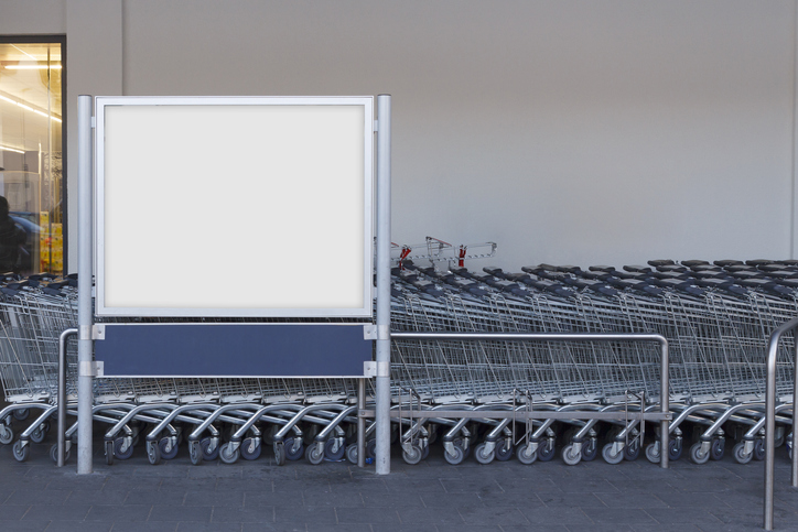 Blank billboard mock up in a supermarket, in front of shopping carts